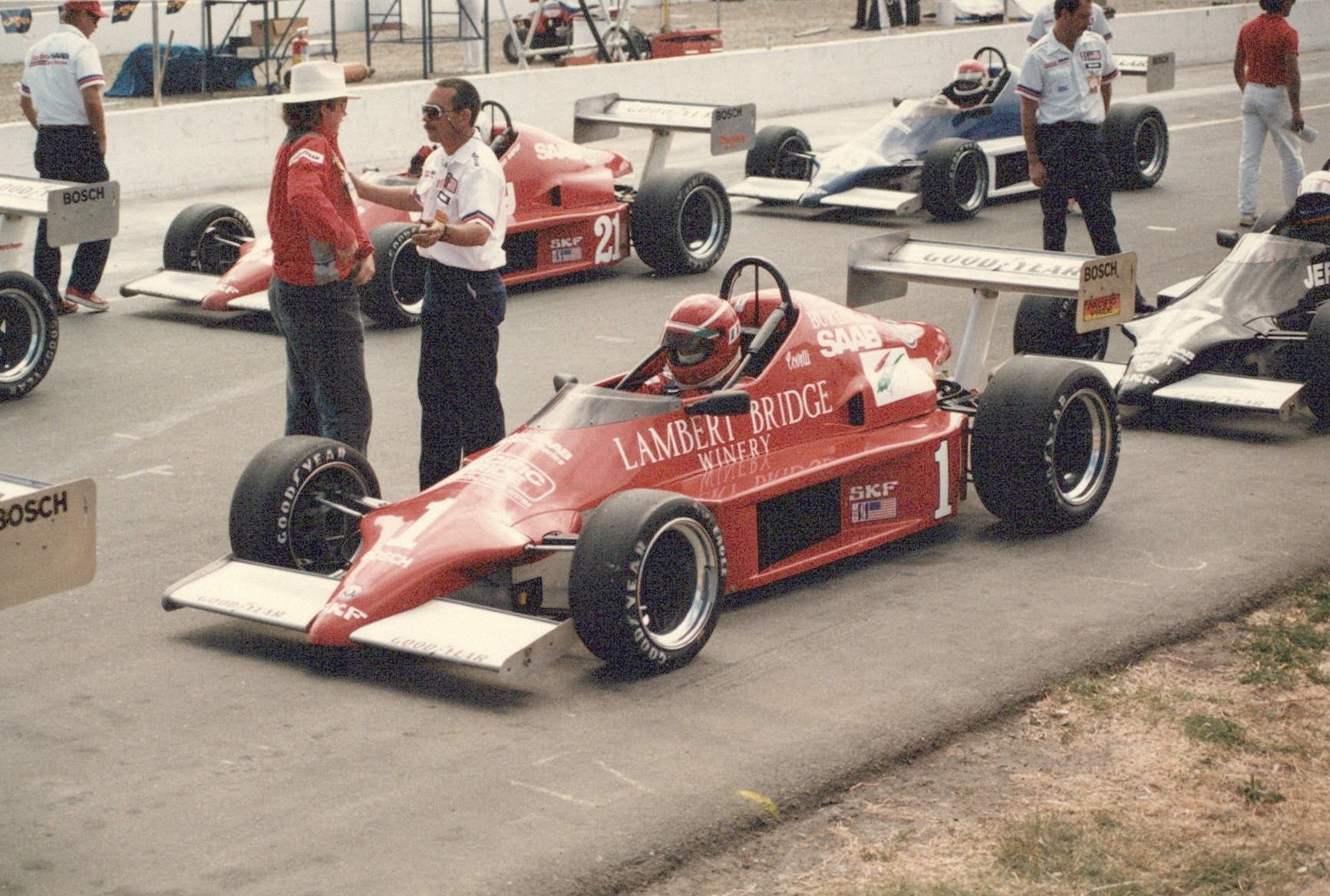 The team's open-wheel car in a busy paddock